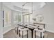 Bright dining room featuring a modern chandelier, shuttered windows, and stylish decor at 2662 N Chestnut Cir, Mesa, AZ 85213
