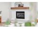Close-up of a white brick fireplace with a wood mantel and decorative accents at 2662 N Chestnut Cir, Mesa, AZ 85213