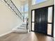 Elegant foyer with a grand staircase, hardwood floors, and a black front door with side lights at 2662 N Chestnut Cir, Mesa, AZ 85213