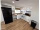 Cozy kitchen with white cabinets, black appliances, and wood-look floors at 303 S Recker Rd # 50, Mesa, AZ 85206