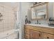 Bright bathroom featuring a shower with decorative tile and a stylish wood vanity with updated fixtures at 3047 W Sandra Ter, Phoenix, AZ 85053