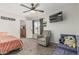 Comfortable bedroom with a ceiling fan, TV, a cozy chair and a view from the window at 3047 W Sandra Ter, Phoenix, AZ 85053
