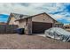 Home exterior with stone detail on the garage, desert landscaping, and gray vehicle covered by a tarp at 3047 W Sandra Ter, Phoenix, AZ 85053
