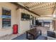 A covered patio with a tv, grill, and space to hang out near the pool at 3047 W Sandra Ter, Phoenix, AZ 85053