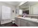 Bright bathroom features white marble countertops, grey cabinets, and dark wood floors at 30517 W Lynwood St, Buckeye, AZ 85396