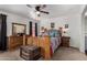 Spacious bedroom features wooden furniture, ceiling fan, and neutral carpet at 30517 W Lynwood St, Buckeye, AZ 85396