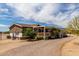 Cozy single-story home featuring desert landscaping, a gravel driveway, and a charming covered front porch at 30517 W Lynwood St, Buckeye, AZ 85396