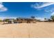 Exterior showcasing a home with solar panels, fenced yard, gravel driveway, and covered parking at 30517 W Lynwood St, Buckeye, AZ 85396