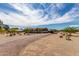 Exterior showcasing the home with mature landscaping, gravel driveway, and covered parking at 30517 W Lynwood St, Buckeye, AZ 85396