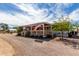 Single-story home featuring a charming covered front porch, gravel landscaping and an American flag at 30517 W Lynwood St, Buckeye, AZ 85396