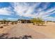 Spacious single-story home with desert landscaping and a long, winding driveway under a cloudy sky at 30517 W Lynwood St, Buckeye, AZ 85396