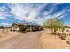 Single-story home featuring desert landscaping, a gravel driveway, and a charming covered front porch at 30517 W Lynwood St, Buckeye, AZ 85396