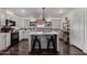 Well-lit kitchen with center island, modern appliances, gray cabinets, and dark hardwood flooring at 30517 W Lynwood St, Buckeye, AZ 85396