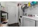 Efficient laundry area with front-load washer/dryer, storage shelves, and a convenient exterior door at 30517 W Lynwood St, Buckeye, AZ 85396