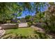 Lush backyard with a brick patio, vibrant greenery, and mature trees, perfect for outdoor living at 3239 S Tatum Ln, Gilbert, AZ 85297
