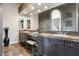 Bathroom vanity with dark wood cabinets, and vessel sinks, a large framed mirror, and stone countertops at 34096 N 87Th Way, Scottsdale, AZ 85266