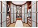 Walk-in closet with custom storage, frosted glass doors, built-in drawers, and bench seating at 34096 N 87Th Way, Scottsdale, AZ 85266