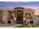 Elegant front entry featuring a stone turret, decorative iron gate, and desert landscaping at 34096 N 87Th Way, Scottsdale, AZ 85266