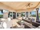 Relaxing covered patio featuring tile flooring, comfortable seating, and beautiful wrought iron doors at 34096 N 87Th Way, Scottsdale, AZ 85266