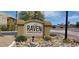 Close-up of The Raven Condominiums sign with desert landscaping along a city street at 3434 E Baseline Rd # 168, Phoenix, AZ 85042