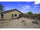 Exterior view of tan home featuring backyard with landscaping and fire pit at 40749 W Thornberry Ln, Maricopa, AZ 85138