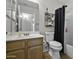 Well-lit bathroom with wood vanity, mirror, toilet, and shower for daily grooming needs at 40749 W Thornberry Ln, Maricopa, AZ 85138