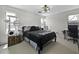 This bright bedroom features a ceiling fan, windows for natural light, and a cozy bed at 40749 W Thornberry Ln, Maricopa, AZ 85138