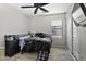 This is a cozy bedroom featuring a ceiling fan, window, and comfortable bed with a black comforter at 40749 W Thornberry Ln, Maricopa, AZ 85138