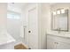 Bright bathroom with a white vanity, modern mirror and walk-in shower with white, vertical tiling at 4521 W Buffalo St, Chandler, AZ 85226