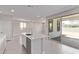 Bright kitchen featuring an island with sink, gray tile floor, stainless steel appliances, and sliding door access at 5016 W Brown St, Glendale, AZ 85302