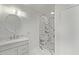 Updated bathroom with a granite-look vanity and walk-in shower featuring stylish marble-look tiling at 5129 W Windrose Dr, Glendale, AZ 85304