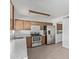 Kitchen featuring stainless steel appliances, wood cabinets, and neutral flooring at 5129 W Windrose Dr, Glendale, AZ 85304