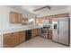 Well-lit kitchen featuring stainless steel appliances, wood cabinets, and tile flooring at 5129 W Windrose Dr, Glendale, AZ 85304