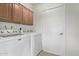 Functional laundry room features a white washer and dryer and storage cabinets at 5129 W Windrose Dr, Glendale, AZ 85304