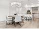 Open concept dining area flowing into the kitchen with stylish light fixture and wood floors at 5250 E Deer Valley Dr # 440, Phoenix, AZ 85054