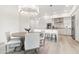 Open concept dining area flowing into the kitchen with stylish light fixture and wood floors at 5250 E Deer Valley Dr # 440, Phoenix, AZ 85054