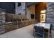 A modern outdoor kitchen boasts stainless steel grills and a dining table on a beautiful stone patio at 5250 E Deer Valley Dr # 440, Phoenix, AZ 85054