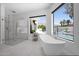 Modern bathroom features a freestanding tub, glass shower, and outdoor views of the pool and mountains at 6321 N Camelback Manor Dr, Paradise Valley, AZ 85253