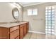 Bathroom with wood cabinets, and glass block window that provides natural light and privacy at 737 E 7Th Pl, Mesa, AZ 85203
