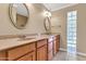 Bathroom with dual sinks, quartz countertops, wood cabinetry, and glass block window at 737 E 7Th Pl, Mesa, AZ 85203