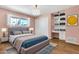 Bedroom with a plush bed, pink walls, hardwood floors, and ample natural light at 737 E 7Th Pl, Mesa, AZ 85203