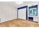 Bedroom featuring a built-in desk, closet, hardwood floors, and blue accent wall at 737 E 7Th Pl, Mesa, AZ 85203