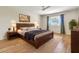 Cozy bedroom featuring a queen-size bed, ceiling fan, and warm wood flooring and decor at 737 E 7Th Pl, Mesa, AZ 85203