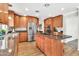 Bright kitchen with stainless steel appliances, custom cabinets, and a functional island with cooktop at 737 E 7Th Pl, Mesa, AZ 85203