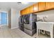 Laundry room with wooden cabinets, laundry sink, and stainless steel washer and dryer at 737 E 7Th Pl, Mesa, AZ 85203