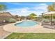 Community pool surrounded by lush landscaping, lounge chairs, and shade umbrellas, perfect for relaxation and recreation at 900 W Broadway Ave # 45, Apache Junction, AZ 85120