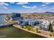 Aerial view of modern white apartment buildings near a Tempe Town Lake with a bridge and city backdrop at 945 E Playa Del Norte Dr # 3002, Tempe, AZ 85288