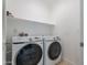 Functional laundry room features a side-by-side washer and dryer with overhead shelving at 945 E Playa Del Norte Dr # 3002, Tempe, AZ 85288