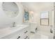 Modern bathroom with dual sinks, vanity, round mirrors, and walk-in shower with decor at 102 S Honeysuckle Ln, Gilbert, AZ 85296