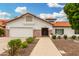 Beautiful single-story home exhibits a desert landscape, tiled roof, and an inviting, covered front porch at 102 S Honeysuckle Ln, Gilbert, AZ 85296